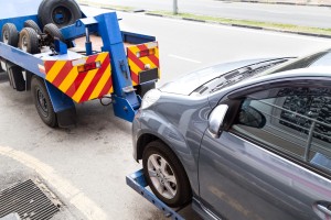 Tow Truck Towing A Broken Down Car On The Street
